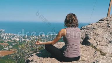 坐在莲花位置练习<strong>瑜伽动作</strong>。 带十字架的悬崖顶部。